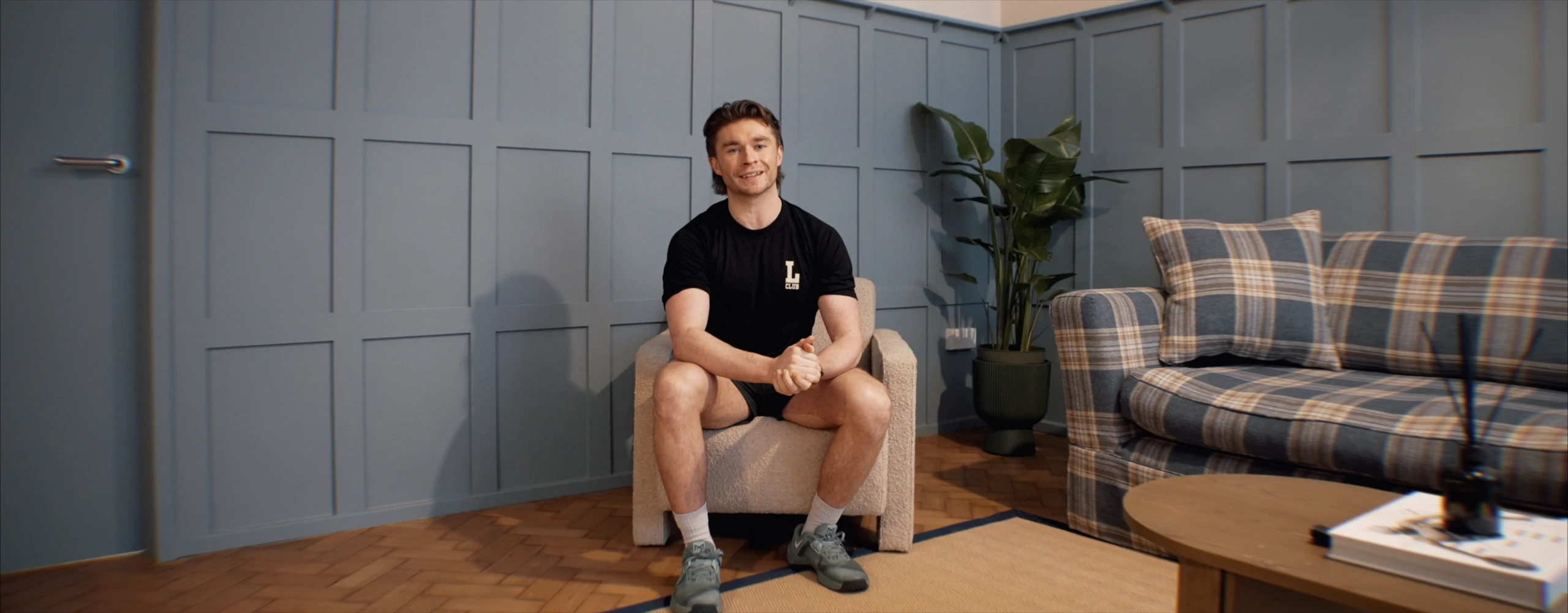 Jake Hitchcock in an armchair in the lounge, smiling at the camera